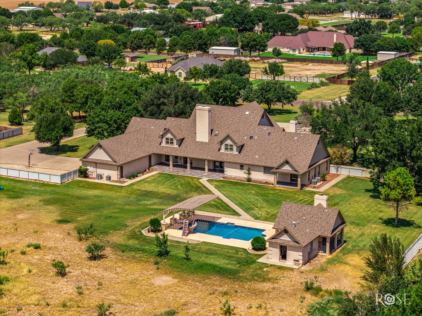 Aerial view of a large estate home with pool and guest house