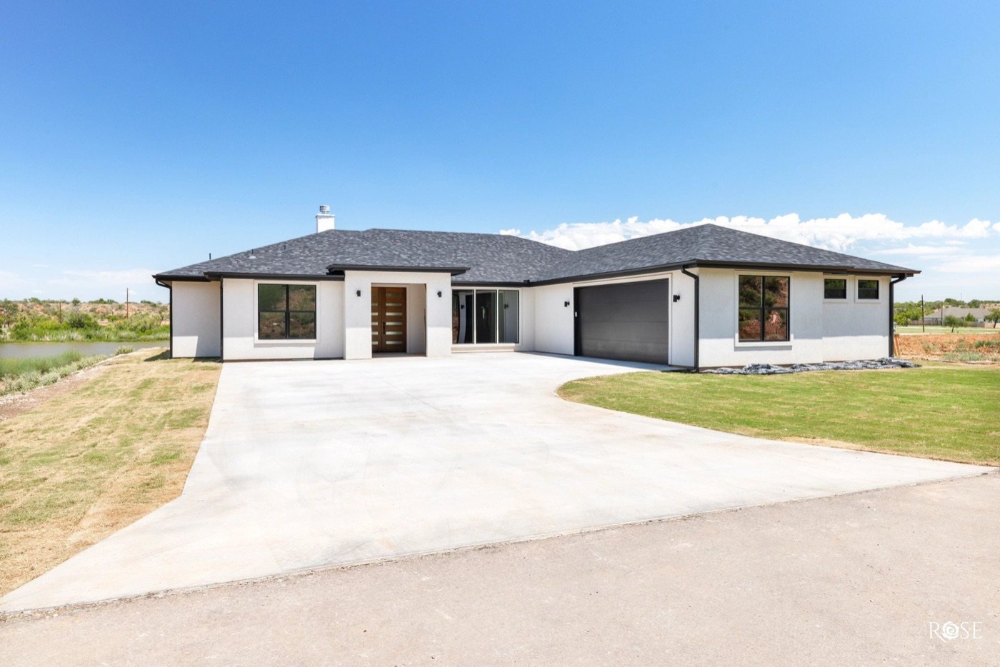 Modern white single-story home with wide concrete drive