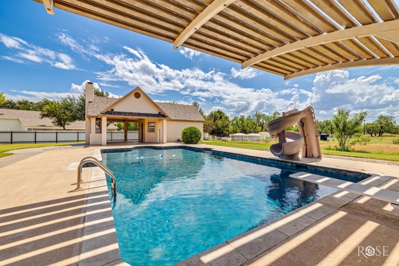 Backyard pool with slide beside a cabana
